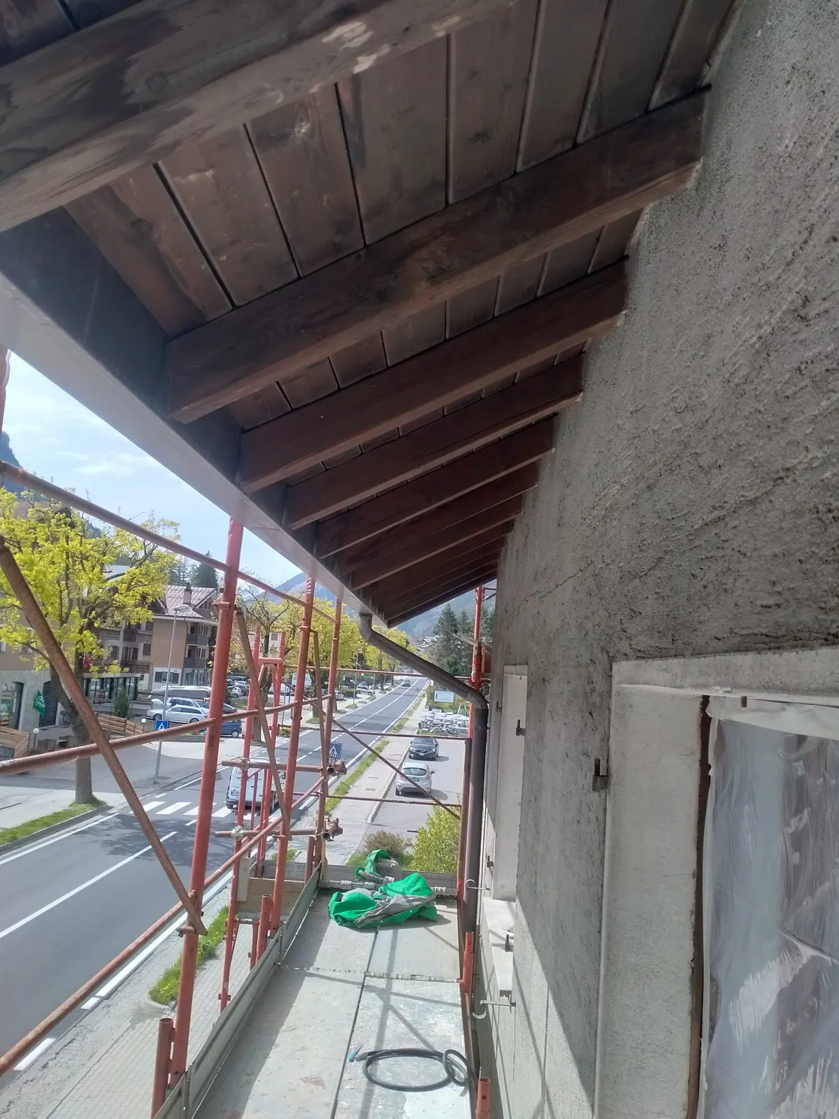 Dachvorsprung mit dunklen Sparren und dunkler Schalung, vor der Arbeit